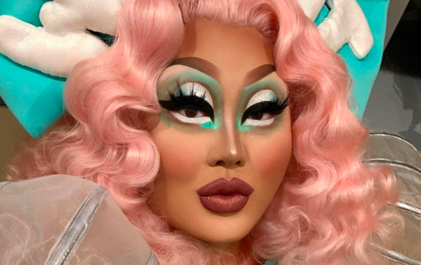 Close up photo of the drag queen Kim Chi with a pink wig and blue and white eyeshadow